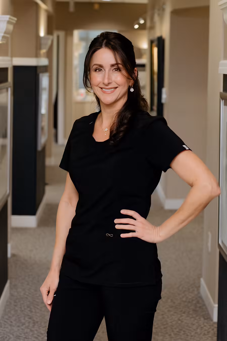 Aileen Portrait of Aileen, dental auxiliary team member at Rainwater Drake Dental, smiling in the office hallway.