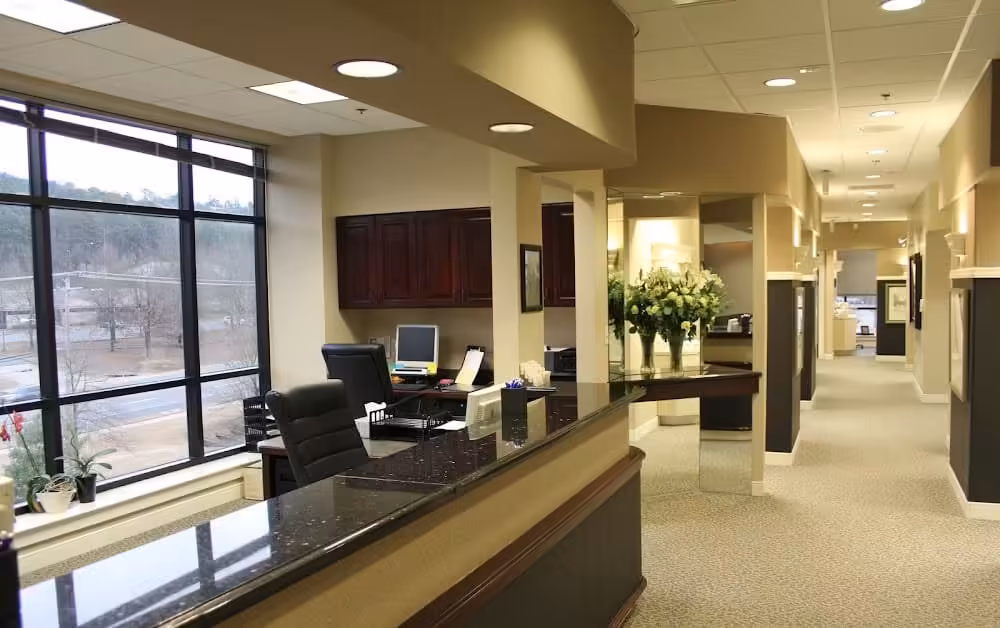 Rainwater Drake Dental reception area Rainwater Drake Dental reception area with granite front desk, large windows, and warm lighting.